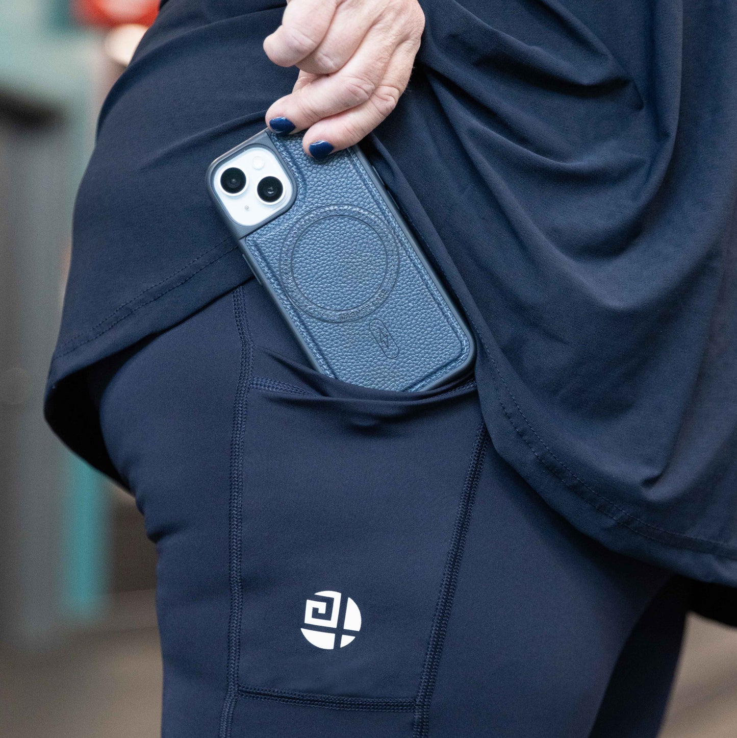 Close-up of Gym Stuff Plus navy high waist leggings showing side pocket holding smartphone, supportive and squat proof fit for plus size women.