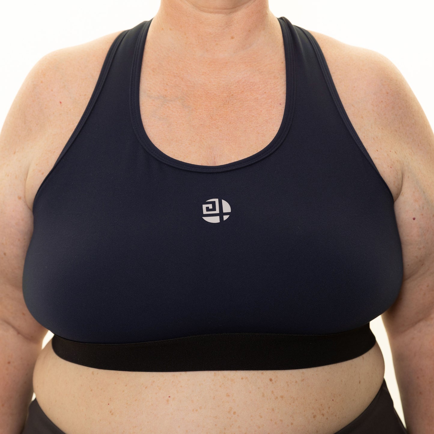 Plus size woman wearing navy high-impact sports bra from Gym Stuff Plus, supportive fit for workouts.