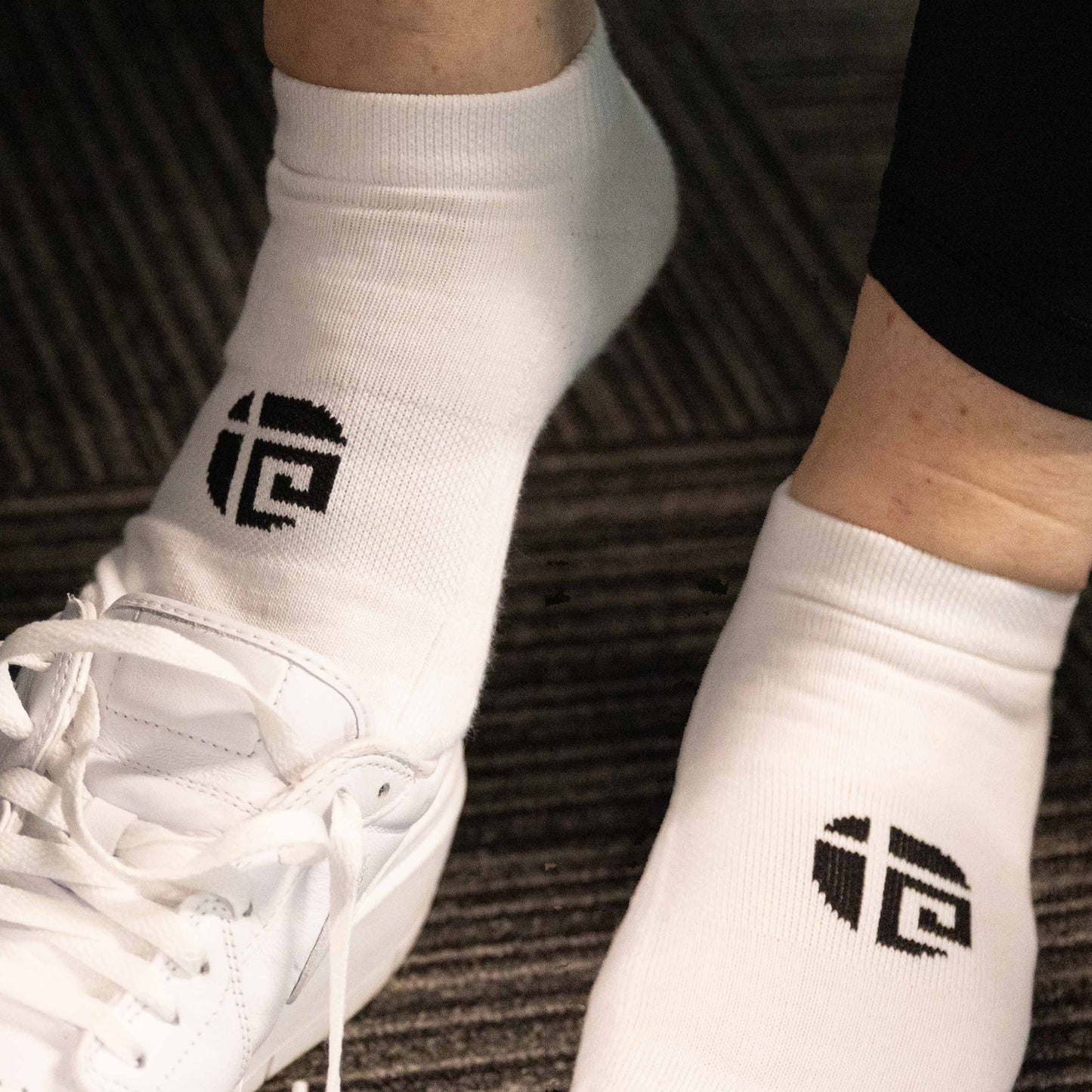 Plus size woman wearing white Gym Stuff Plus ankle sport socks with trainers, comfortable fit for gym and everyday wear.