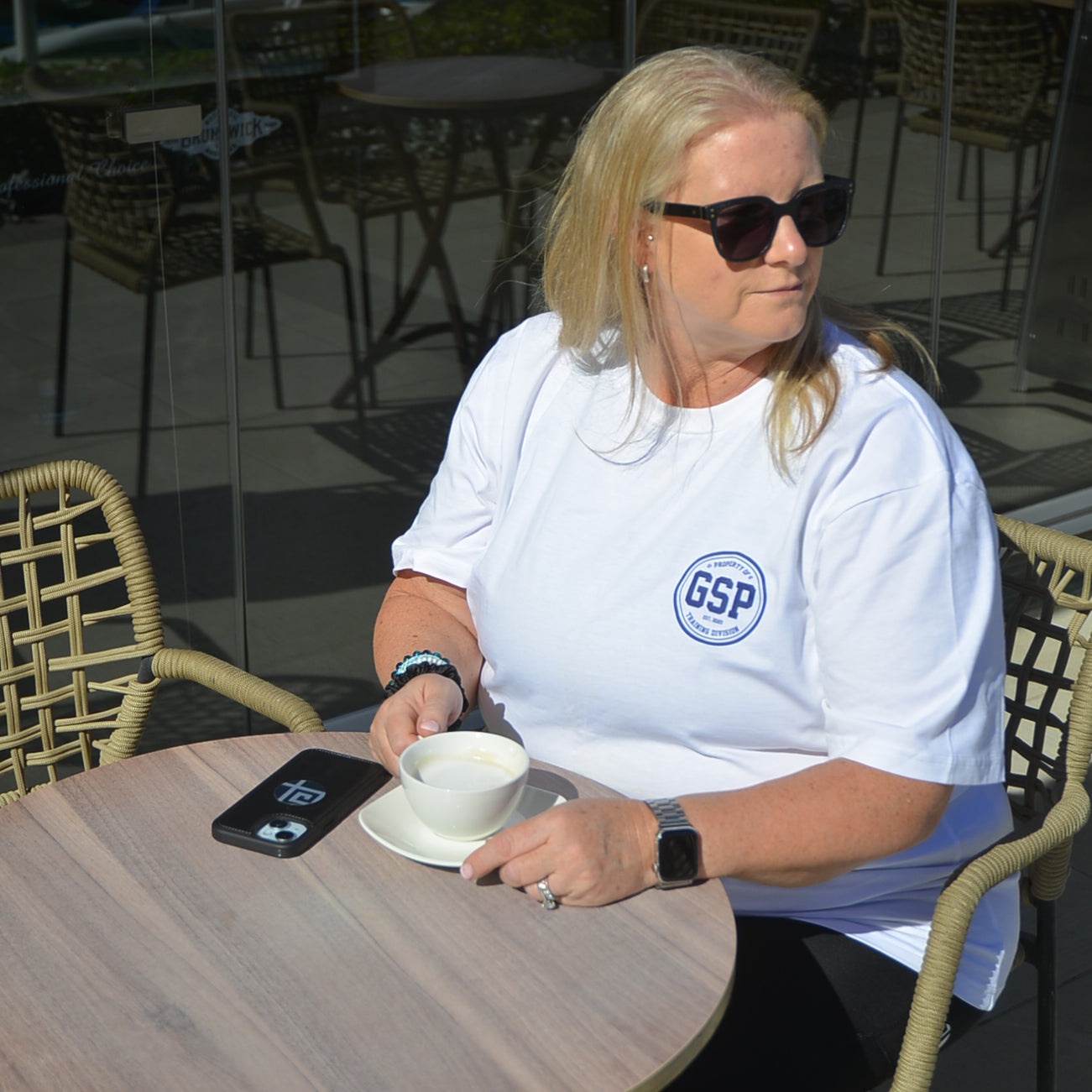 plus size white off duty t-shirt women sitting at cafe gsp logo